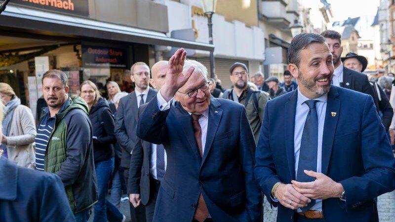 Bundespräsident Frank-Walter Steinmeier (l) begrüßt während seines Rundgangs durch die Fußgängerzone Passanten.
