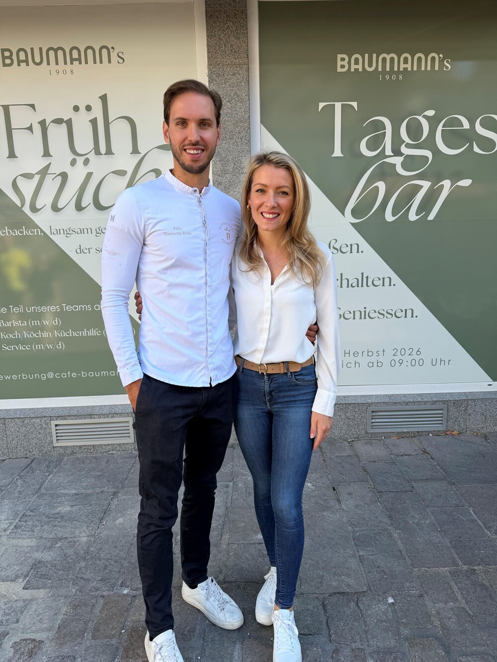 Die Baumann-Inhaber Felix und Melina Warnecke-Brühl vor ihrem neuen Café am Jesuitenplatz, welches im Herbst 2026 eröffnen soll. Die Baumann-Inhaber Felix und Melina Warnecke-Brühl vor ihrem neuen Café am Jesuitenplatz, welches im Herbst 2026 eröffnen soll.