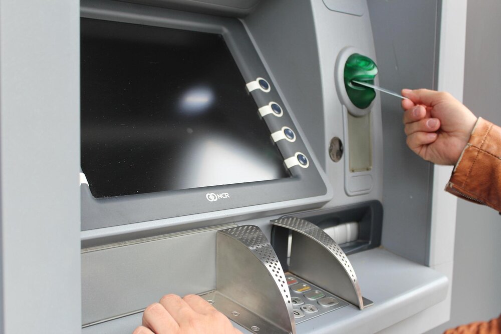 Eine Person hebt Geld an einem Geldautomaten ab. Eine Person hebt Geld an einem Geldautomaten ab.