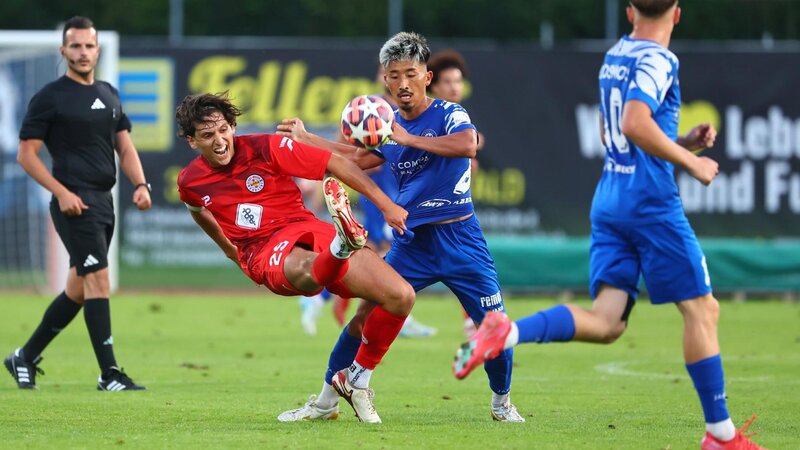 Spielszene vom Koblenzer Stadtduell zwischen dem FC Rot-Weiss (rotes Trikot) und dem FC Cosmos (ganz in Blau) im Stadion Oberwerth.