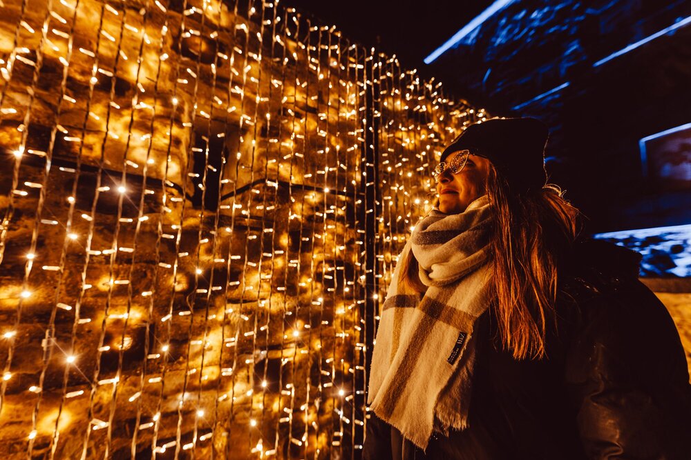 Frau vor einer Lichtinstallation im Christmas Garden in Koblenz.