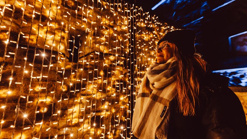 Frau vor einer Lichtinstallation im Christmas Garden in Koblenz.