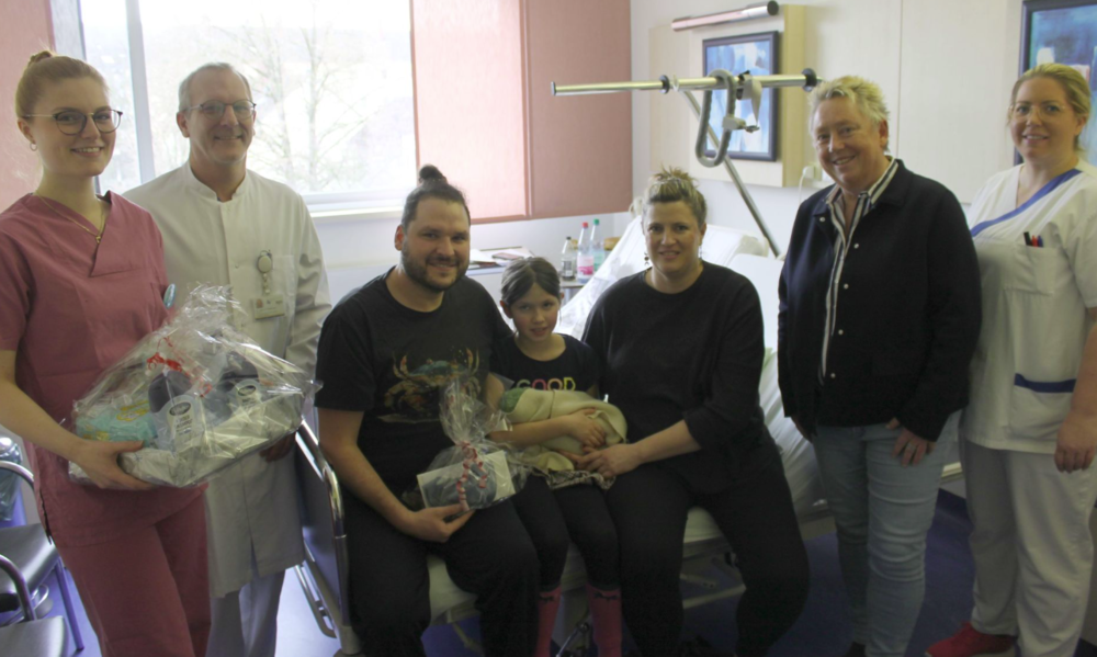 Das Foto zeigt die stolzen Eltern ihre Tochter Maya flankierend, die ihren Bruder im Arm hält, sowie stehend v.l. Hebamme Sophie Urmersbach, Oberarzt Dr. med. Sebastian Friederichs, Bürgermei Das Foto zeigt die stolzen Eltern ihre Tochter Maya flankierend, die ihren Bruder im Arm hält, sowie stehend v.l. Hebamme Sophie Urmersbach, Oberarzt Dr. med. Sebastian Friederichs, Bürgermei