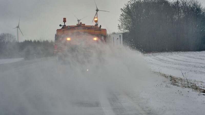 wei Fahrzeuge der Straßenmeisterei sind auf der B327 unterwegs, um Schnee und Schneeverwehungen von der Fahrbahn zu beseitigen.