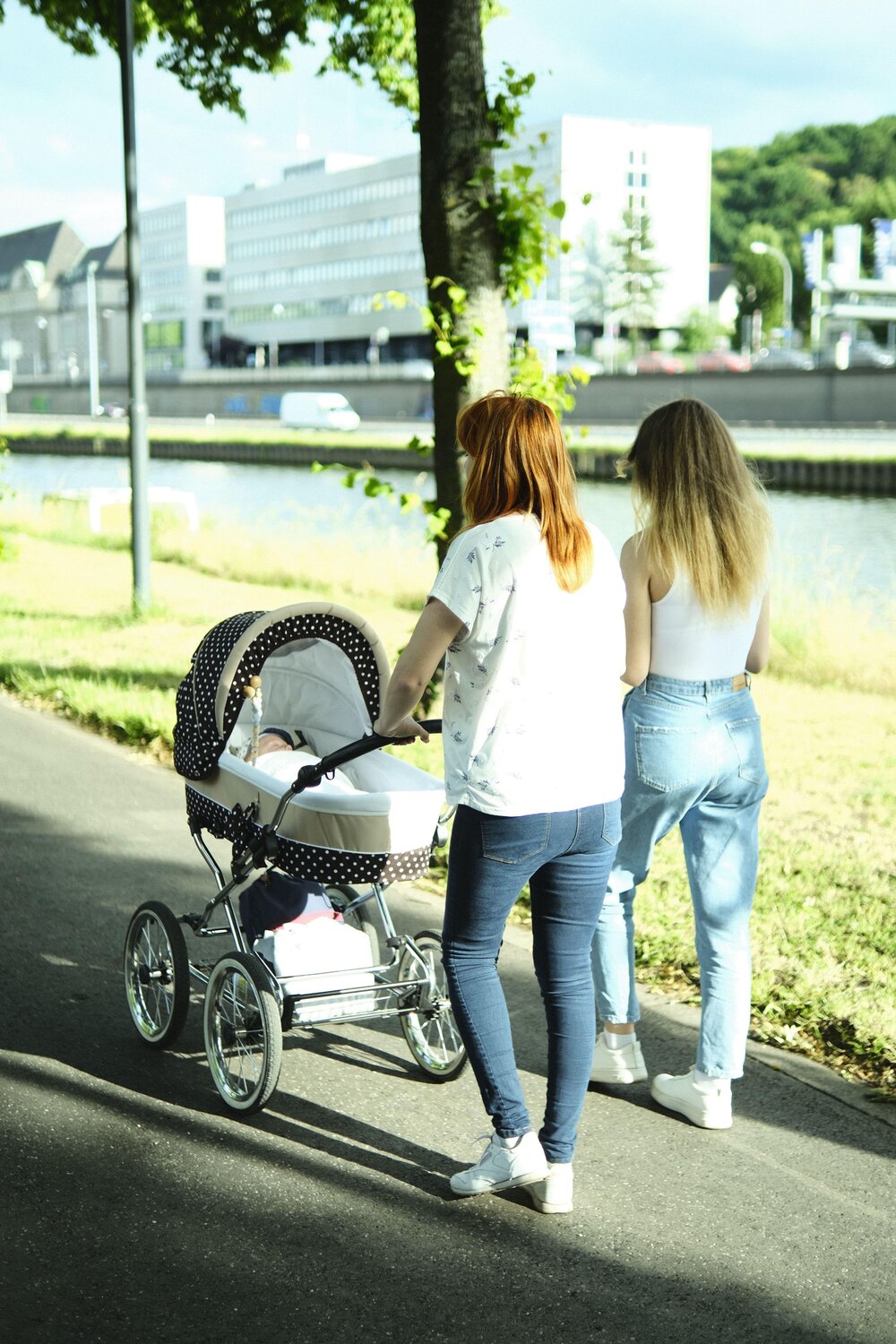 Zwei Frauen gehen mit einem Kinderwagen spazieren (Symbolbild). Zwei Frauen gehen mit einem Kinderwagen spazieren (Symbolbild).