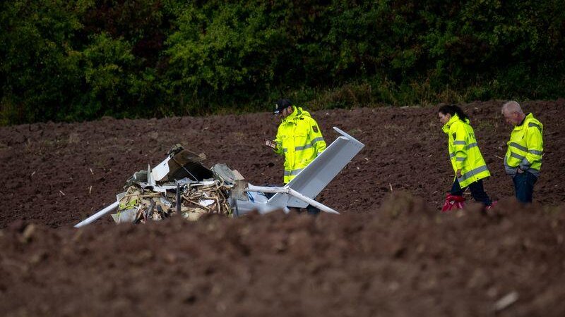 Polizisten untersuchen das Wrack des Ultraleichtflugzeugs.