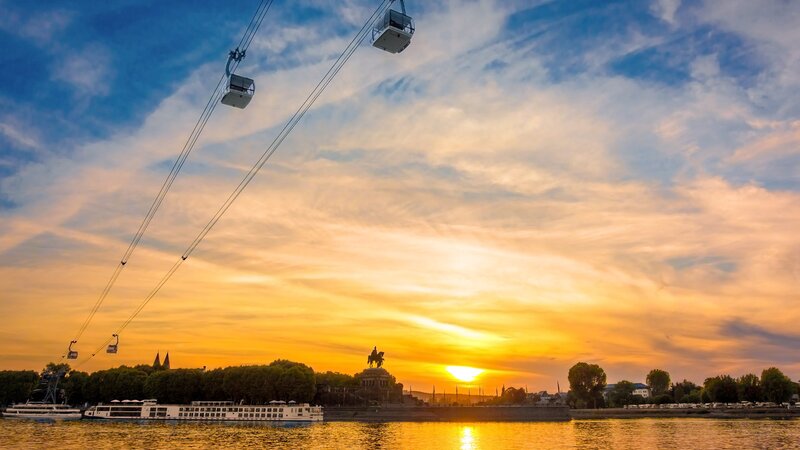 Abendhimmel in Koblenz, die Sonne geht unter, die Seilbahn fährt und das Deutsche Eck sowie der Rhein sind in Sichtweite