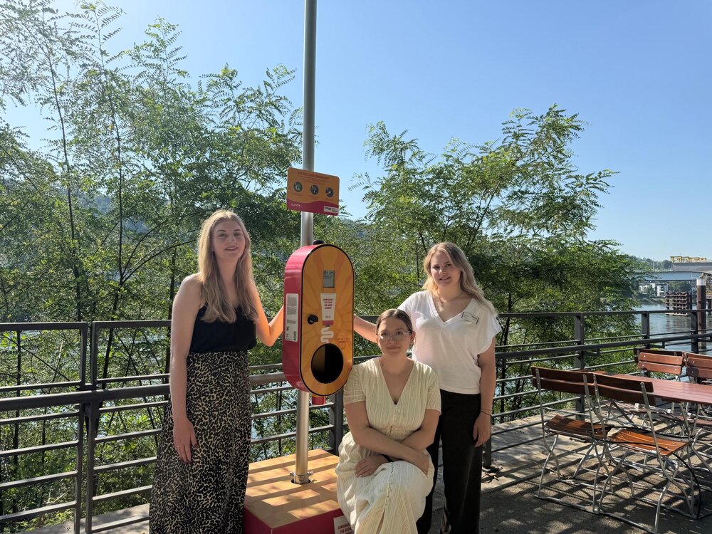 Der Sonnencreme-Spender stammt aus einer gemeinsamen Initiative der Klimaleitstelle der Stadt Koblenz (Emilie Hammer, mitte), des Kultur- und Schulverwaltungsamts (Rebekka Jachmig, links) und