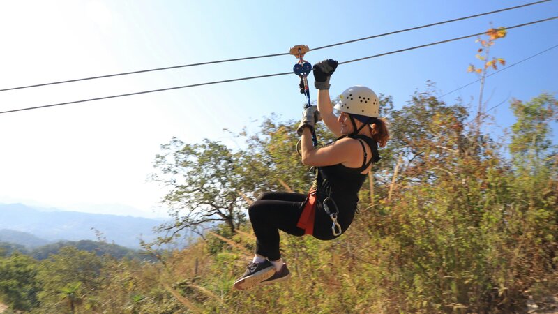 Eine Frau flitzt auf einer Zipline durch die Luft (Symbolbild)