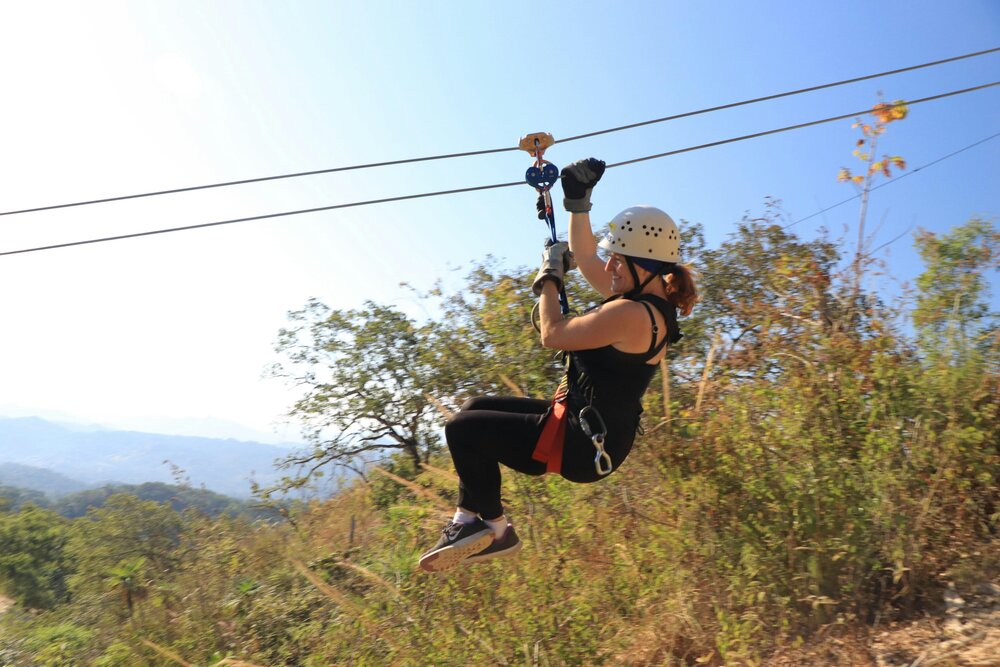 Eine Frau flitzt auf einer Zipline durch die Luft (Symbolbild)