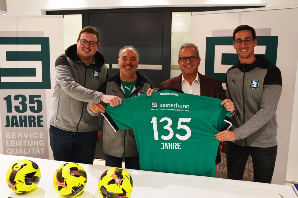 Die Vorstandmitglieder Max Jacobs (links), Wolfgang Knöll (2. von links) und Niclas Kuhn (rechts) brachten Johannes Sesterhenn (2. von rechts) zur Auslosung ein SG-Trikot zum 135-Jährigen Jub