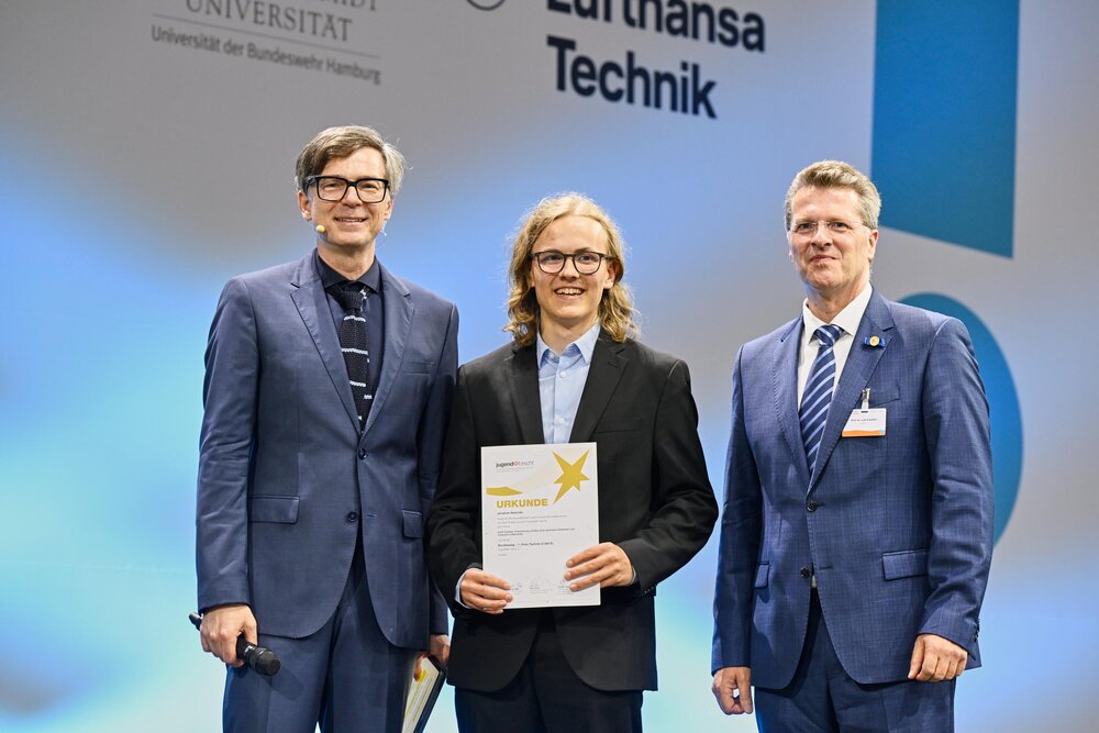 Jonathan Baschek (Mitte) erhielt die Urkunde aus den Händen von Professor Lutz Eckstein (rechts). Links: Moderator Ralf Caspers