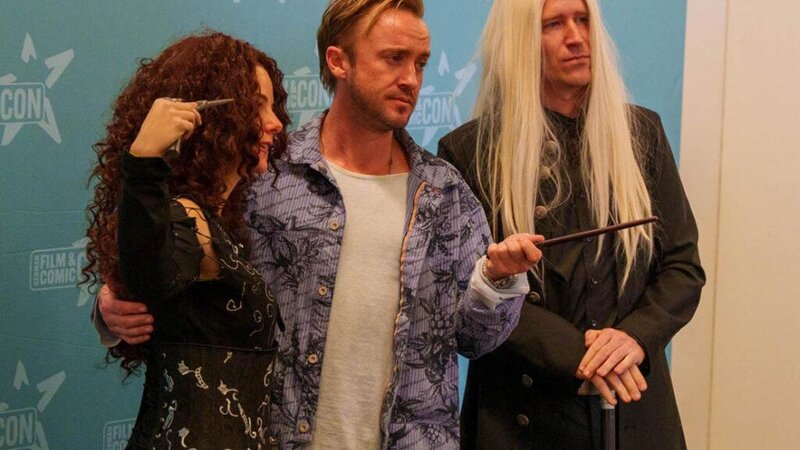 Harry Potter Star Tom Felton macht ein Foto mit zwei Fans.