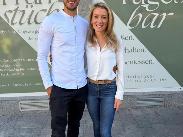 Die Baumann-Inhaber Felix und Melina Warnecke-Brühl vor ihrem neuen Café am Jesuitenplatz, welches im Herbst 2026 eröffnen soll.