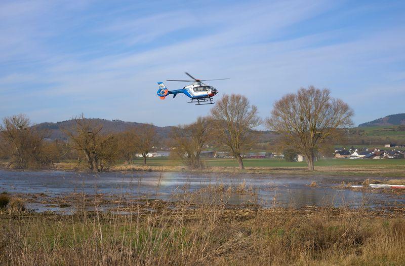 Ein Polizeihubschrauber hilft mit seinem Staustrahl, das Naturschutzgebiet zu reinigen.