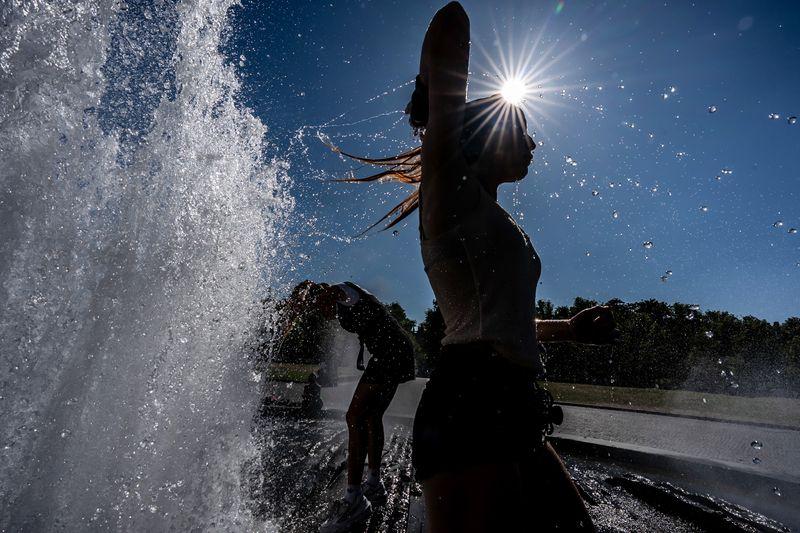 Temperaturen von annähernd 40 Grad in der Hauptstadt - diese Touristen nutzen einen Brunnen zur Abkühlung.