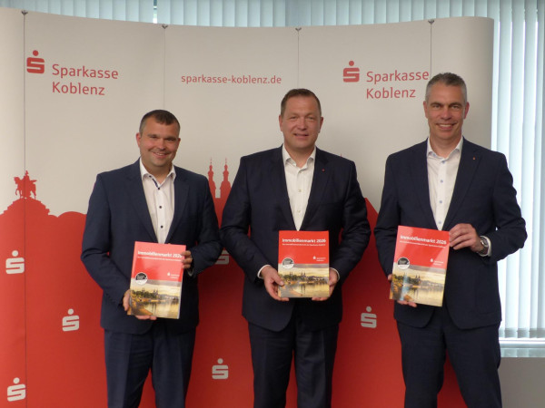 v. links: Sven Alsbach (Abteilungsleiter des  Immobilienvermittlungscenters), Christoph Stibbe (Vorstand der  Sparkasse Koblenz) und Frank Roth (stv. Vorstandsmitglied und  Bereichsleiter Private Banking, Immobilien- und  Versicherungsgeschäft) stellen den neuen Immobilienmarktbericht 2026 vor.