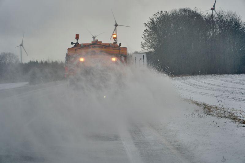 wei Fahrzeuge der Straßenmeisterei sind auf der B327 unterwegs, um Schnee und Schneeverwehungen von der Fahrbahn zu beseitigen.